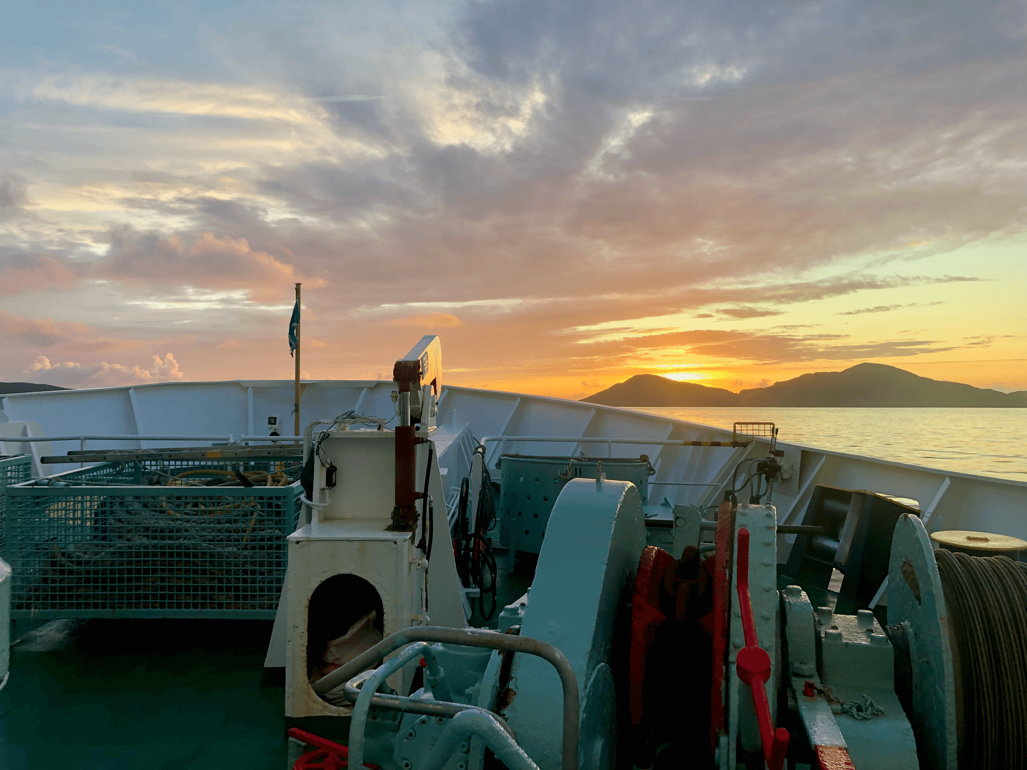 The bow of a ferry in the foreground, islands in the background.